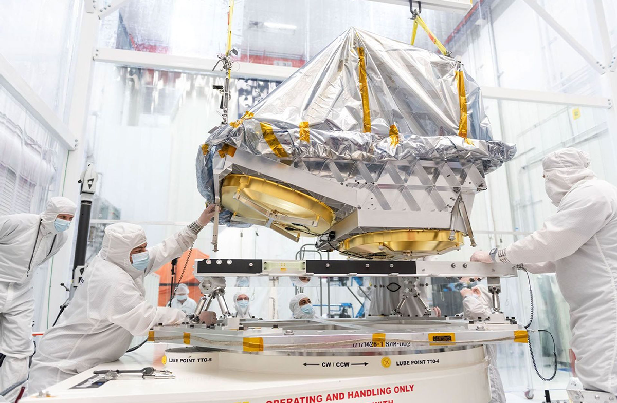 We wrześniu 2025 roku inżynierowie montują aluminiowy teleskop przeznaczony dla sondy NEO Surveyor należącej do NASA na ramie nośnej w laboratorium Space Dynamics Laboratory w Logan w stanie Utah. Teleskop jest połączony za pomocą systemu rozpórek, które zapobiegają przenoszeniu ciepła ze statku kosmicznego na instrument | źródło: Space Dynamics Laboratory/Allison Bills