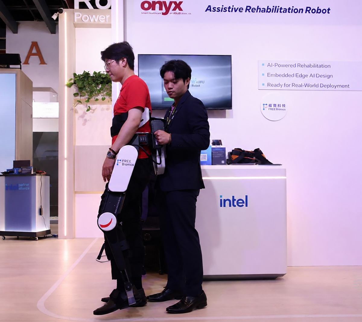 Podczas targów Computex Taiwan 2026 Eason Lin, dyrektor ds. sprzedaży w firmie Onyx Healthcare (w kombinezonie), prezentuje egzoszkielet wyposażony w procesory z rodziny Intel® Core™ Ultra oraz oprogramowanie Intel® OpenVINO™. (Źródło zdjęcia: Intel Corporation).